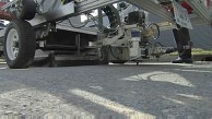 Stra&szlig;enreparatur mit asphaltspritzendem Roboter